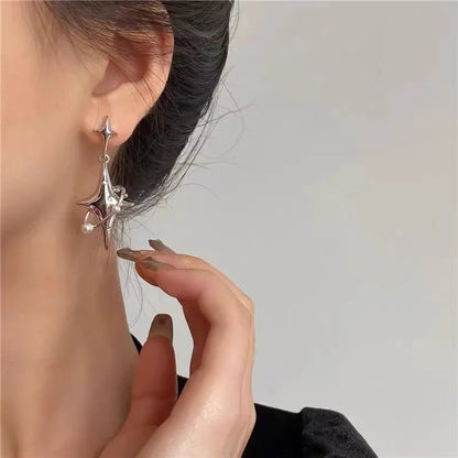 silver nova earrings, in ear, front view